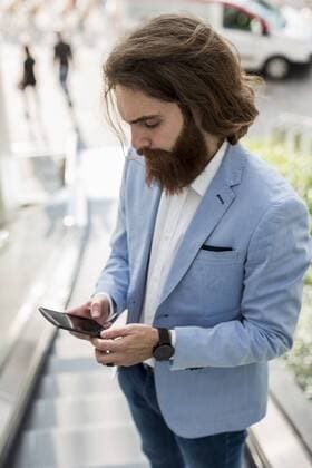 Stylish businessman using cell phone on escalator model released Symbolfoto  MAUF000768