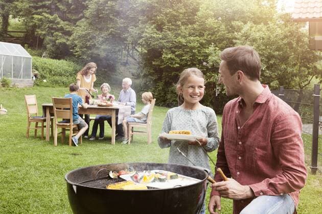 Grillen mit der Familie - Model Released Smiling father and daughter on a family barbecue model released Symbolfoto property released  RBF004774