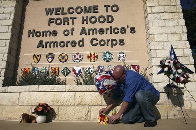 FOR METRO - U.S. Army Spc. Ryan Hill lays flowers near the main entrance to Fort Hood Army Post Saturday Nov. 7, 2009 in Fort Hood, Tx. PHOTO BY EDWARD A. ORNELAS eaornelas@express-news.net) - ZUMAa27_