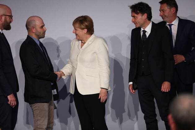Presentation of the M100 Media Prize in Potsdam The presentation of the M100 Media Prize in the Orangery Palace in Potsdam was attended by Chancellor Dr. Angela Merkel, Roberto Saviano, author ( Gomorrah ), journalist and M100 Media Award winners 2016 Giobanni di Lorenzo, editor in chief, Die Zeit and Jann Jakobs, Lord Mayor of Landeshauptstad Potsdam.  SimonexKuhlmey
