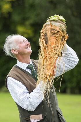 September 16, 2016 - Harrogate, Yorkshire, UK - Harrogate UK. Picture shows Peter Glazebrook & his prize winning carrot that weighed 7.9 kg at the Giant vegetable competition in Harrogate. The competition see s competitors from across the UK show their biggest Carrot s, Cucumbers, Cabbages, Onion s & Tomatoes competing for the title of heaviest & longest at the Harrogate Autumn Flower Show. Harrogate UK  - ZUMAl94_