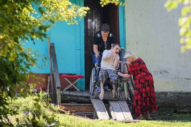 September 23, 2016 - Village Of Alekseyevka, Tambov region, Russia - Person with disabilities (handicapped in wheelchair) help to down on the street. Photo taken in the village of Alekseyevka, Znamensky district, Tambov region, Russia Village Of Alekseyevka Russia - ZUMAs171