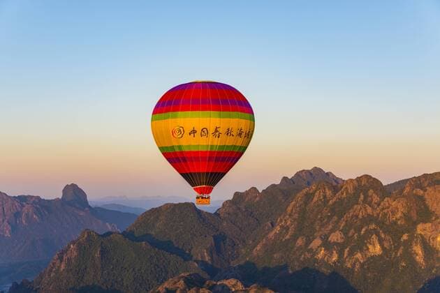  Bunter Heißluftballon in der Luft, hinten Karstberge, Vang Vieng, Vientiane, Laos, Asien Copyright: imageBROKER/ValentinxWolf iblvfw04390994.jpg