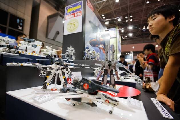 Visitors look at action figures of the fiction mecha anime Macross at the 56th All Japan Model & Hobby Show in Tokyo Big Sight on September 25, 2016. The exhibition introduced hobby goods such as plastic models, action figures, drones, and airsoft guns.  (gxta_alljpnmodelhobbyshow011)