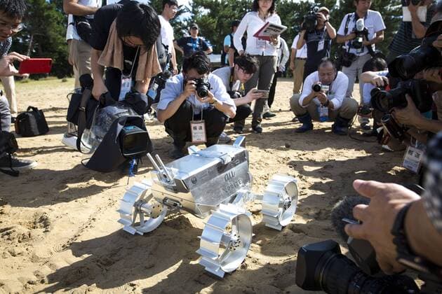September 27, 2016 - Tottori, Tottori Prefecture, Japan - Cameraman take photos of Hakuto s rover PFM3 pre-flight model which is being tested by team ispace, Tohoku University researchers and students in Tottori Sand Dunes, Tottori Prefecture, Japan on September 27, 2016. Mounted on AstroboticÃ¢â‚¬â„¢s Ã¢â‚¬Å PeregrineÃ¢â‚¬Â lander, HAKUTOÃ¢â‚¬â„¢s rover will be launched from the Earth by SpaceXÃ¢â‚¬â„¢s Falcon 9 rocket, and sent to lunar orbit. The Peregrine lander will achieve soft landing on the moon. The rover is then deployed onto the MoonÃ¢â‚¬â„¢s surface..(Photo by Richard Atrero de Guzman NURPhoto) Tottori Japan  - ZUMAn230