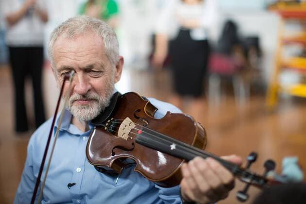 September 27, 2016 - Liverpool, Merseyside, UK - Liverpool , UK . Labour Party leader JEREMY CORBYN is shown how to play the violin by JESSICA KELLY (10) during a visit to Faith Primary School in Liverpool , where he listens to and then joins in with the school orchestra Liverpool UK  - ZUMAl94_