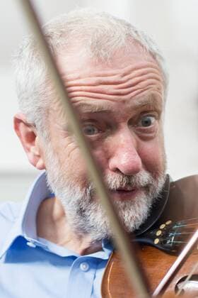 September 27, 2016 - Liverpool, Merseyside, UK - Liverpool , UK . Labour Party leader JEREMY CORBYN is shown how to play the violin by JESSICA KELLY (10) during a visit to Faith Primary School in Liverpool , where he listens to and then joins in with the school orchestra Liverpool UK  - ZUMAl94_