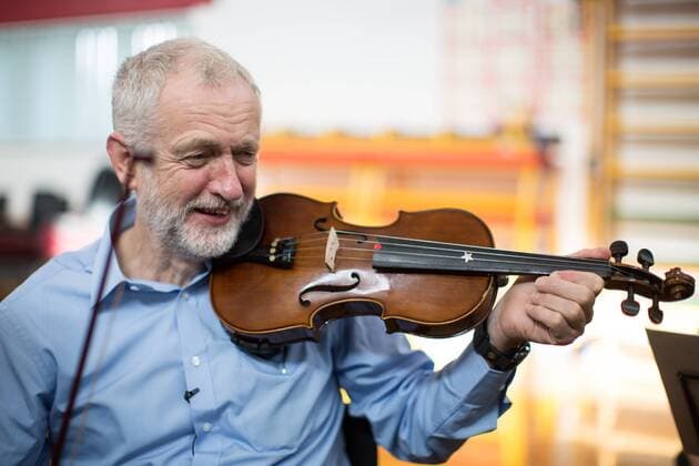 September 27, 2016 - Liverpool, Merseyside, UK - Liverpool , UK . Labour Party leader JEREMY CORBYN is shown how to play the violin by JESSICA KELLY (10) during a visit to Faith Primary School in Liverpool , where he listens to and then joins in with the school orchestra Liverpool UK  - ZUMAl94_