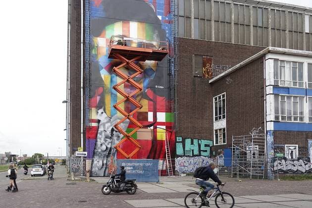 The Netherlands, Amsterdam. The famous Brazilian street artist Eduardo Kobra realizes this week a monumental portrait of Anne Frank. 26 september 2016, Photo: Katrien Mulder Hollandse Hoogte Nederland, Amsterdam, Amsterdam Noord, NDSM Terrein, wereldberoende Braziliaanse streetartist Eduardo Kobra realiseert deze week een monumentaal portret van Anne Frank op de zuidelijke buitenmuur van de loods op de hoek van de MS van Riemsdijkweg, en de Tt Neveritaweg famous Brazilian street artist Eduardo Kobra realizes this week a monumental portrait of Anne Frank,26 september 2016, foto: Katrien Mulder  59396758