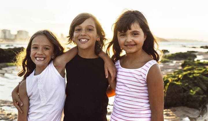 Portrait of three happy kids on the beach at sunset model released Symbolfoto  MGOF002296