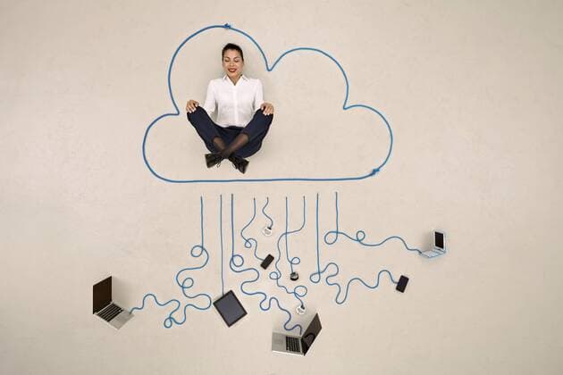 Businesswoman meditating in a cloud connected to mobile devices model released Symbolfoto  BAEF001111