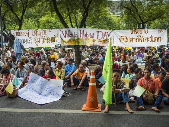 October 3, 2016 - Bangkok, Bangkok, Thailand - Slum dwellers from across Thailand sit in front of the UN headquarters in Bangkok during a World Habitat Day protest. In 1985, the UN General Assembly declared that World Habitat Day would be observed on the first Monday of October every year. The declaration noted that every person deserves a decent place to live. In Bangkok this year, hundreds of people marched to the United Nations offices to deliver a letter addressed to the UN Secretary General noting that forced evictions to facilitate urban renewal and gentrification was resulting in an increase in homelessness and substandard housing. Protesters and housing rights activists also marched to the Prime Minister s Office and Bangkok city hall to express their concerns. Bangkok Thailand - ZUMAk94_