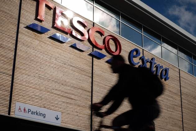 October 5, 2016 - Portsmouth, Hampshire, UK - Portsmouth, Hampshire, UK. A man cycling past a Tesco Extra in Portsmouth this morning. Tesco PLC, Britain s largest supermarket chain has announced that like-for-like sales had grown in the first half of its financial year. The results come following increased competition in the market from budget supermarkets such as Aldi & Lidl. Portsmouth UK  - ZUMAl94_