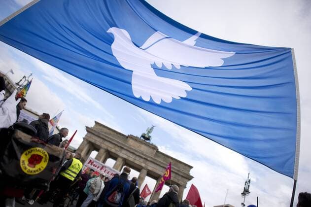 Friedensdemo DEU, Deutschland, Germany, Berlin, 08.10.2016 Demonstranten mit Transparent Friedenstaube auf der Kundgebung und bundesweiten Friedensdemonstration von einem Aktionsbuendnis unter dem Motto Die Waffen Nieder Kooperation statt Nato-Konfrontation, Abruestung statt Sozialabbau vor dem Brandenburger Tor in Berlin. Die Demonstranten fordern: keinen Einsatz der Bundeswehr, Stopp aller Waffenlieferungen und eine politische Selbstbestimmung fuer Syrien. Protestler with peace sign at the peace demonstration under the slogan Cooperation instead of Nato confontation, disarmament instead of social cuts against the deployment of German military forces Bundeswehr in foreign countries and arms delivery in front of the Brandenburger Gate in Berlin, Germany