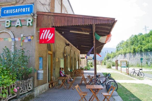 Rennradfahrer auf dem Alpe Adria-Weg zwischen Villach und Venzone im alten Bahnhof von Chiusaforte. Dort ist nun ein Cafe Restaurant untergebracht Chiusaforte Nord-Italien Italien Alpe-Adria-Weg
