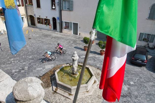 Rennradfahrer auf dem Alpe Adria-Weg auf der Piazza in Venzone, 1976 vom Erdbeben zerstört und wieder aufgebaut Venzone Nord-Italien Italien Alpe-Adria-Weg