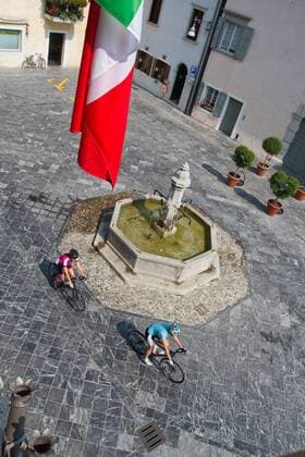Rennradfahrer auf dem Alpe Adria-Weg auf der Piazza in Venzone, 1976 vom Erdbeben zerstört und wieder aufgebaut Venzone Nord-Italien Italien Alpe-Adria-Weg