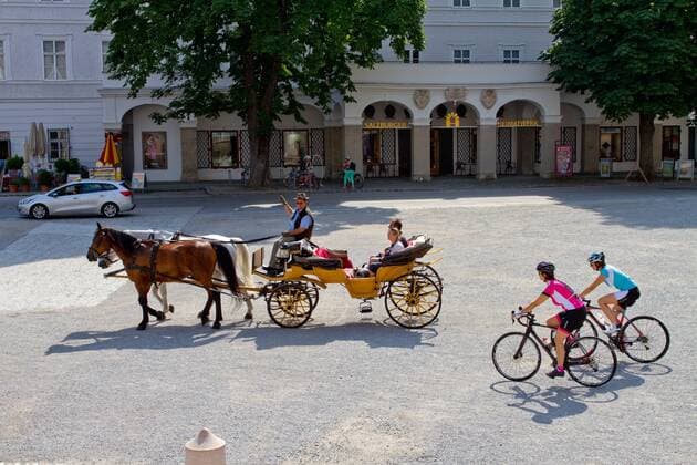 Fiaker Pferdekutsche am Residenzplatz in der Altstadt in Salzburg mit Rennradfahrern Salzburg Salzburger Land Österreich Salzburg