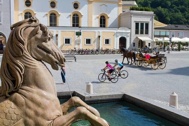 Fiaker Pferdekutsche am Residenzplatz in der Altstadt in Salzburg mit Rennradfahrern Salzburg Salzburger Land Österreich Salzburg