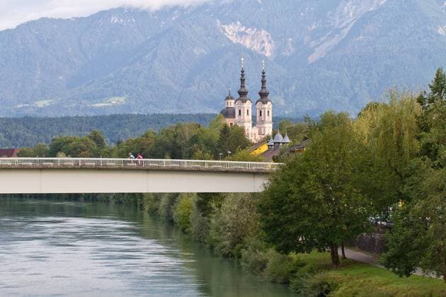 Rennradfahrer auf der Brücke vor der heiligen Kreuz Kirche in Villach Villach Kärnten Österreich