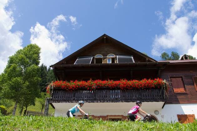 Rennradfahrer auf dem Alpe Adria-Weg zwischen Villach und Venzone vor dem Balkon eines Bauernhauses Nord-Italien Italien Alpe-Adria-Weg