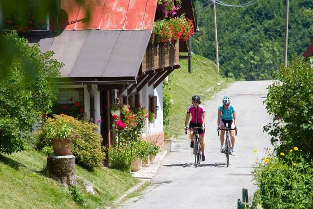 Rennradfahrer auf dem Alpe Adria-Weg zwischen Villach und Venzone vor dem Balkon eines Bauernhauses Nord-Italien Italien Alpe-Adria-Weg