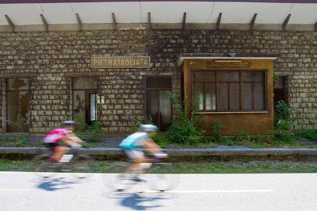 Rennradfahrer vor einer alten Bahnstation auf dem Alpe Adria-Weg zwischen Villach und Venzone Nord-Italien Italien Alpe-Adria-Weg