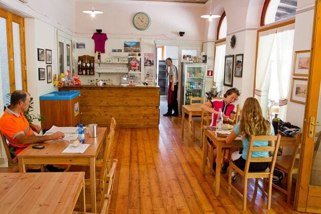 Rennradfahrer auf dem Alpe Adria-Weg zwischen Villach und Venzone im alten Bahnhof von Chiusaforte. Dort ist nun ein Cafe Restaurant untergebracht Chiusaforte Nord-Italien Italien Alpe-Adria-Weg