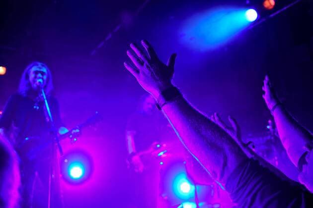 17.10.2016 --- New Model Army performing live on stage at Hirsch in Nuremberg, Germany on 17th October 2016 --- A fan lifts his arms ----- Justin Sullivan - lead vocals, guitar --- New Model Army live in concert