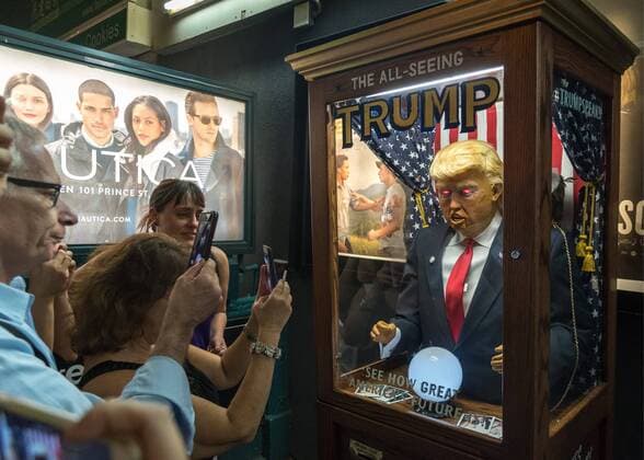 People surround and photograph a fortune-telling fairground attraction representing Republican presidential candidate Donald Trump outside a New York theater screening the premiere of the documentary Michael Moore In TrumpLand on October 18, 2016. Filmmaker Michael Moore had finished editing the film the previous day and made a surprise last-minute announcement on Twitter that he would show it for free today. The film will play for a week in Los Angeles and New York starting tomorrow. Photo by Enrique Shore Cordon Press  ENRIQUExSHORE People surround robot of Trump before the premiere of the docume