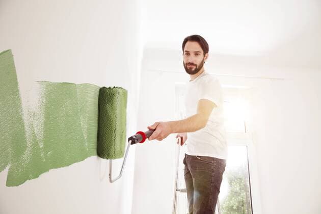 Young man painting a wall green model released Symbolfoto property released  MFF003271