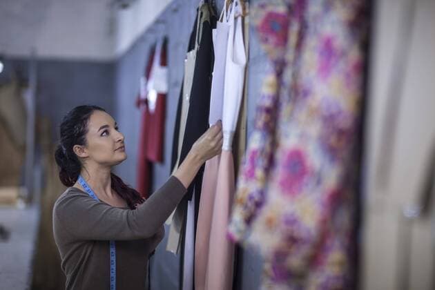 Fashion designer checking dresses in factory model released Symbolfoto property released  ZEF10522