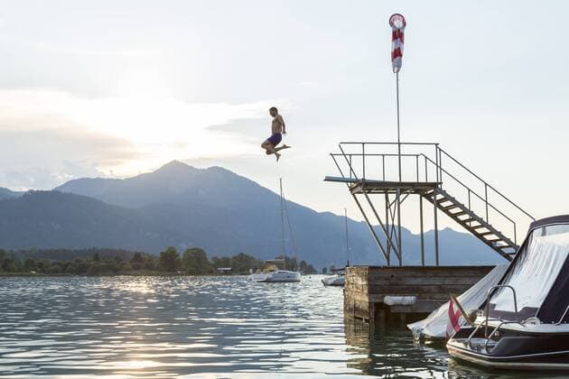 Austria, Sankt Wolfgang, man jumping from platform into lake model released Symbolfoto  JUNF00643
