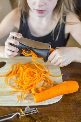 Girl using spiral vegetable slicer, partial view model released Symbolfoto  SARF03009