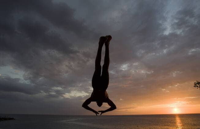 Jamaica, Negril, Silhouette of young man leaping from from cliff above Pirates Cave  Copyright: xPaulxSoudersx xDanitaxDelimont CA22 PSO0015