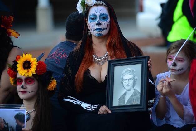 Bilder des Tages Dia de los Muertos: Tag der Toten in New Mexiko, USA November 6, 2016 - Albuquerque, NEW MEXICO, U.S. - 110616. Andrea Camp,<cq.>, holds a photograph of her late mother Norma Jean Vargas,<cq>, who passed away 4 years ago, while on a float during the 24th Annual Dia de los Muertos Marigold Parade.Photographed on Sunday November 6, 2016. . JOURNAL. Albuquerque U.S. - ZUMAab1_ 20161106_zaf_ab1_019