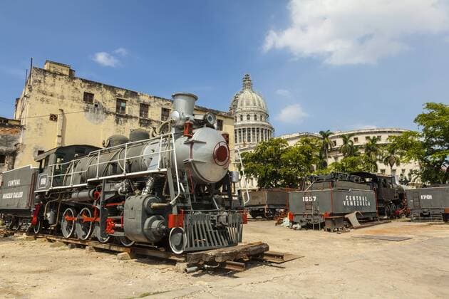 A vintage steam train in a restoration yard with the dome of the former Parliament Building in the background, Havana, Cuba, West Indies, Caribbean, Central America Copyright: SeanxCooper 1231-6