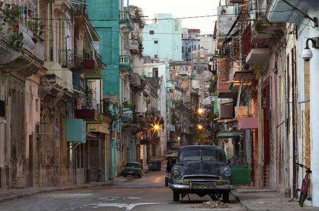 Street scene before sunrise showing dilapidated buildings crowded together and vintage American cars, Havana Centro, Havana, Cuba, West Indies, Caribbean, Central America Copyright: LeexFrost 321-5509