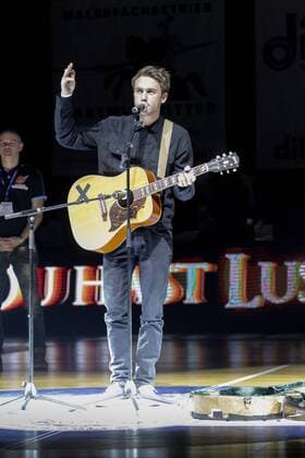 Erfurt, 221116 , Oettinger Rockets gegen NÜR Nürnberg Falcons BC im Bild: Clueso singt mit Gitarre auf dem Spielfeld , Thomas Hübner