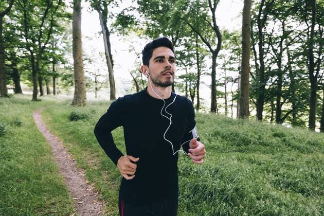 Man running on forest track model released Symbolfoto  BOYF00630