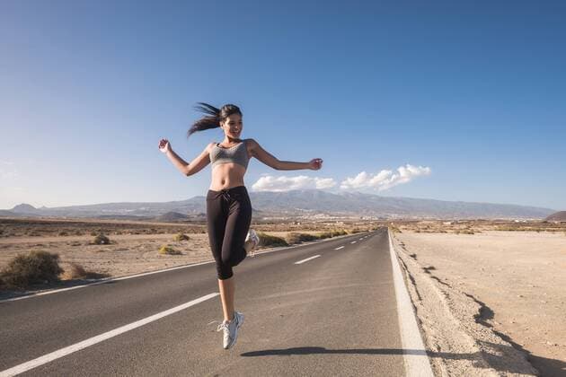 Sportive young woman jumping on a road model released Symbolfoto  SIPF01035