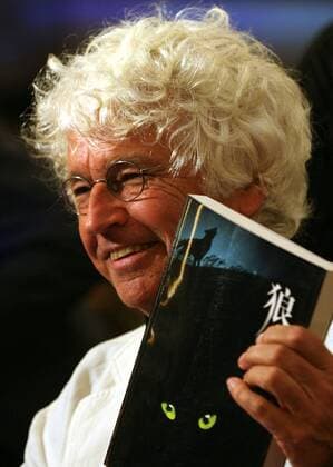 Aug 19, 2009 - Beijing, China - French director JEAN-JACQUES ANNAUD kisses the novel Wolf Totem by Chinese writer Jiang Rong during a press conference for the filming of Wolf Totem in Beijing. Jean-Jacques Annaud will direct the Chinese-language film Wolf Totem. The project will be the first Chinese-invested film to be directed by a foreign filmmaker.  - ZUMAc32_ 20090819_jab_c32_166