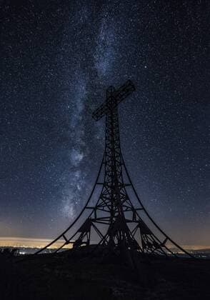 Italy, Marche, silhouette of summit cross on Monte Catria at night  LOMF00438