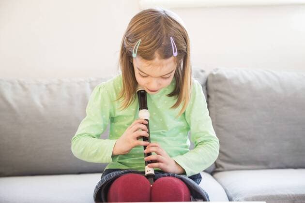 Little girl sitting on couch with recorder model released Symbolfoto  LVF05629