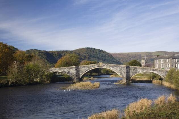 Pont Fawr Bridge, arched stone bridge built by Inigo Jones in 1636, Conwy River, and in autumn with mountains in Snowdonia National Park beyond, Llanrwst, Conwy, Wales, United Kingdom, Europe Copyright: PearlxBucknall 586-1345