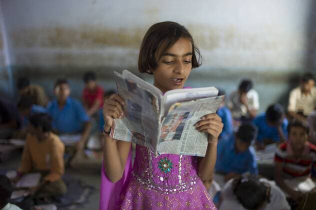 Indian girl reading aloud during English lesson at Rajyakaiya School in Narlai village, Rajasthan, Northern India Copyright: TimxGraham 1161-5139