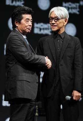 December 21, 2016, Tokyo, Japan - Japanese composer Ryuichi Sakamoto, a member of the Yellow Magic Orchestra (YMO) is celebrated from his friend and a Japanese author Ryu Murakami (L) after he received Montblanc de la Culture Arts Patronage Award in Tokyo on Wednesday, December 21, 2016. Sakamoto played his screen music Merry Christmas Mr. Lawrence with young musicians.  (lwxa006998)