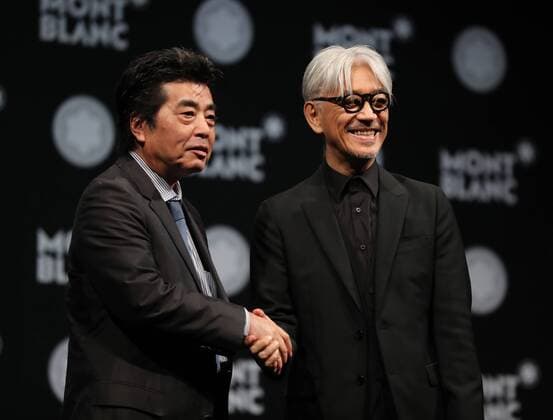 December 21, 2016, Tokyo, Japan - Japanese composer Ryuichi Sakamoto, a member of the Yellow Magic Orchestra (YMO) is celebrated from his friend and a Japanese author Ryu Murakami (L) after he received Montblanc de la Culture Arts Patronage Award in Tokyo on Wednesday, December 21, 2016. Sakamoto played his screen music Merry Christmas Mr. Lawrence with young musicians.  (lwxa007002)