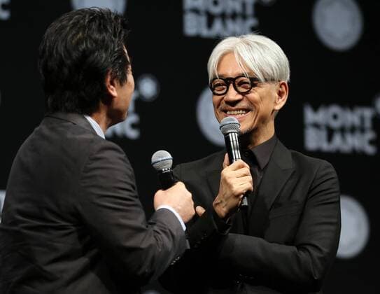 December 21, 2016, Tokyo, Japan - Japanese composer Ryuichi Sakamoto, a member of the Yellow Magic Orchestra (YMO) is celebrated from his friend and a Japanese author Ryu Murakami (L) after he received Montblanc de la Culture Arts Patronage Award in Tokyo on Wednesday, December 21, 2016. Sakamoto played his screen music Merry Christmas Mr. Lawrence with young musicians.  (lwxa007003)