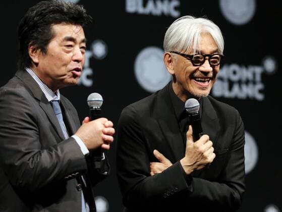 December 21, 2016, Tokyo, Japan - Japanese composer Ryuichi Sakamoto, a member of the Yellow Magic Orchestra (YMO) is celebrated from his friend and a Japanese author Ryu Murakami (L) after he received Montblanc de la Culture Arts Patronage Award in Tokyo on Wednesday, December 21, 2016. Sakamoto played his screen music Merry Christmas Mr. Lawrence with young musicians.  (lwxa007005)